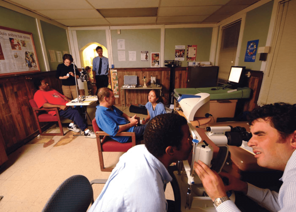 Dr. Waxman overlooks an exam room where three patients are being treated by a medical student volunteer. 